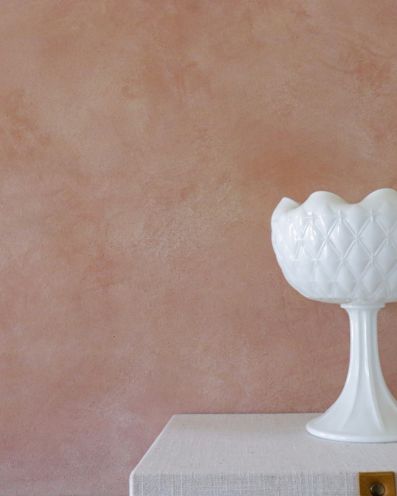 Pink and white swirls of limewash color on the walls with a white milk glass vase.